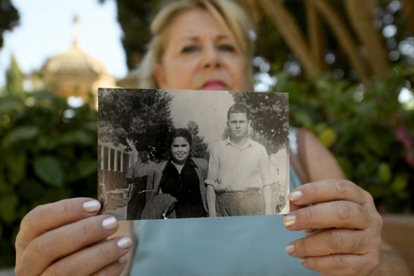 Maria Jose Pico Robles, who seeks trace of her diseappeared sister, holds an old photograph of her parents as she poses in the cemetery in the cemetery of Alicante, on August 19, 2022. - Almost five decades after the death of Francisco Franco, Spanish lawmakers voted through a flagship law on October 5, 2022 seeking to honour the victims of the 1936-1939 civil war and the ensuing dictatorship. (Photo by Jose Jordan / AFP)